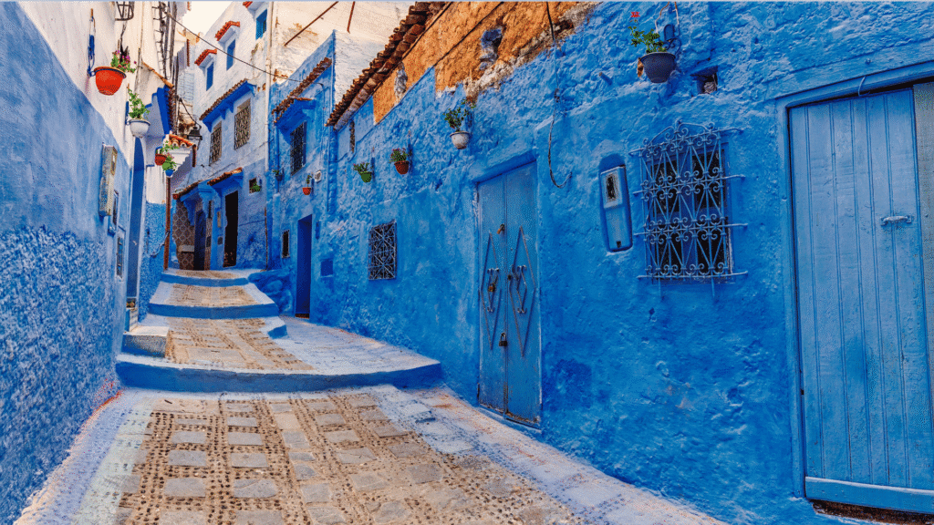 Blue and white medina buildings around a quiet Chefchaouen courtyard